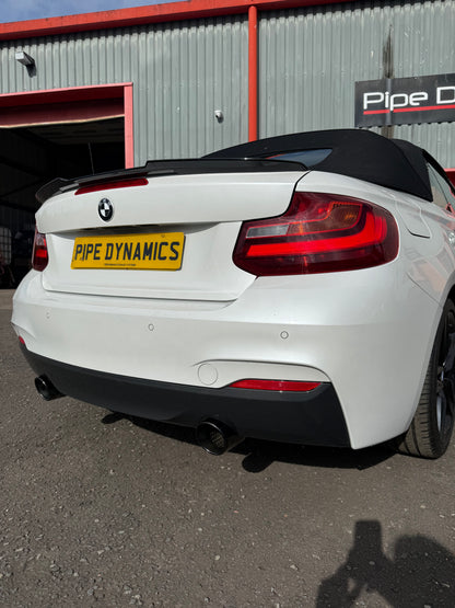 White BMW 2 Series 220d Convertible rear view with a black soft top, black diffuser, and a PIPE DYNAMICS EXHAUST